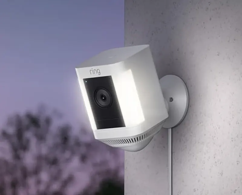 Ring Spotlight Cam Plus mounted outdoors showing dual LED spotlights activated at night